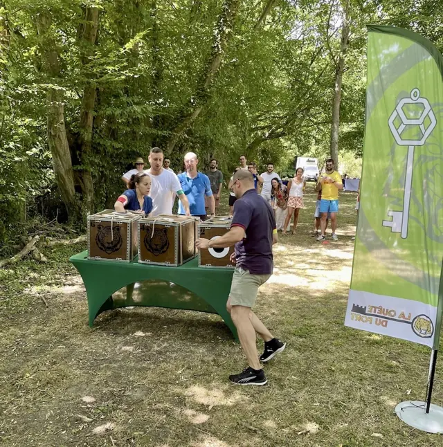 Équipe qui résout une épreuve à énigmes sur des coffres en bois